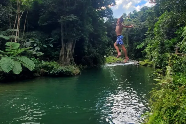 a man standing next to a body of water surrounded by trees